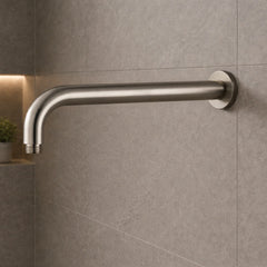 Metallic shower arm mounted on a tiled wall