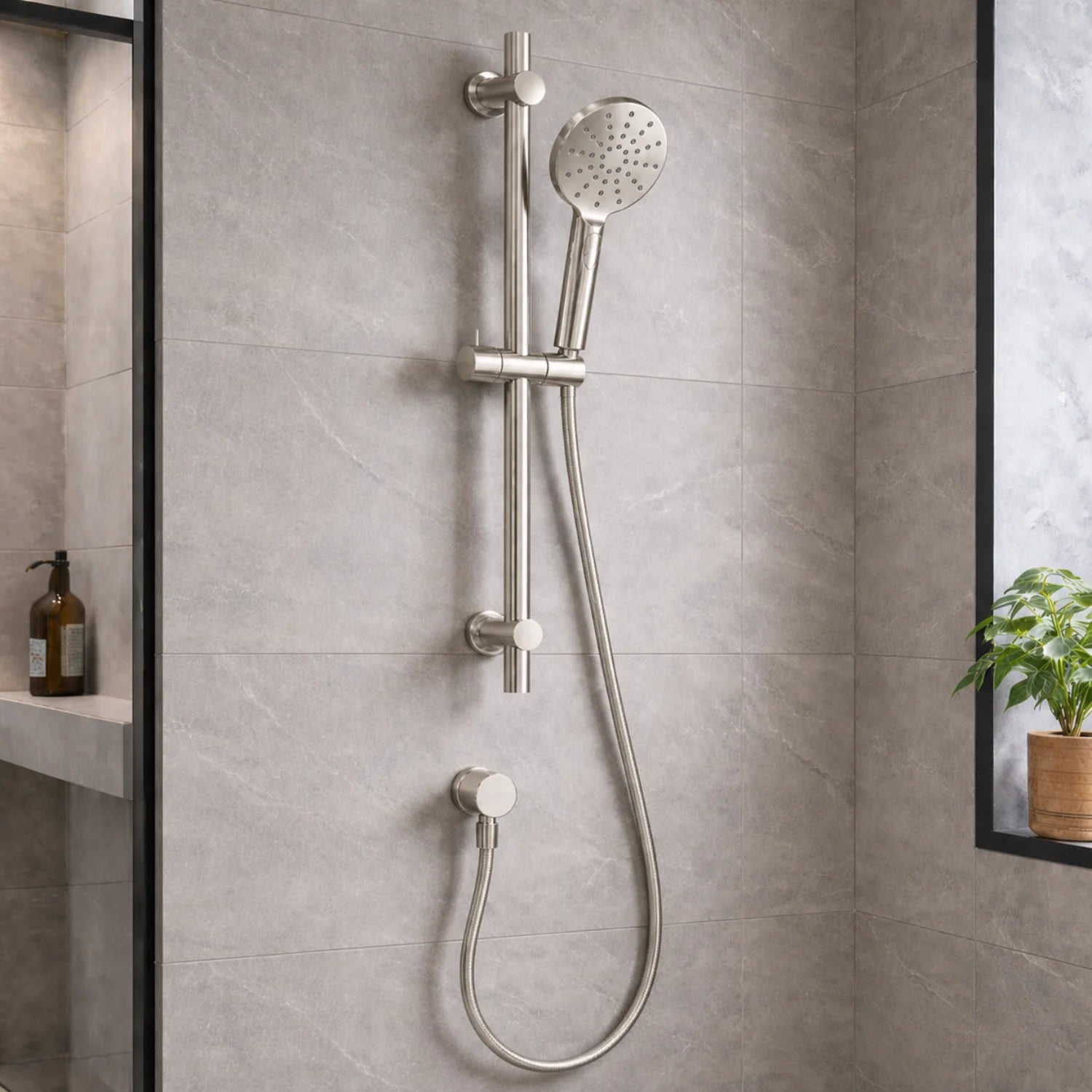 Shower head and control handle mounted on a tiled bathroom wall.