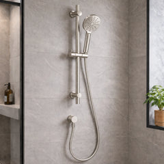 Shower head and control handle mounted on a tiled bathroom wall.