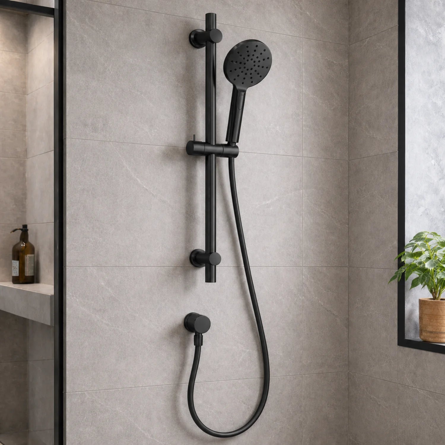 Black shower head and hose mounted on a tiled bathroom wall.