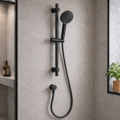 Black shower head and hose mounted on a tiled bathroom wall.