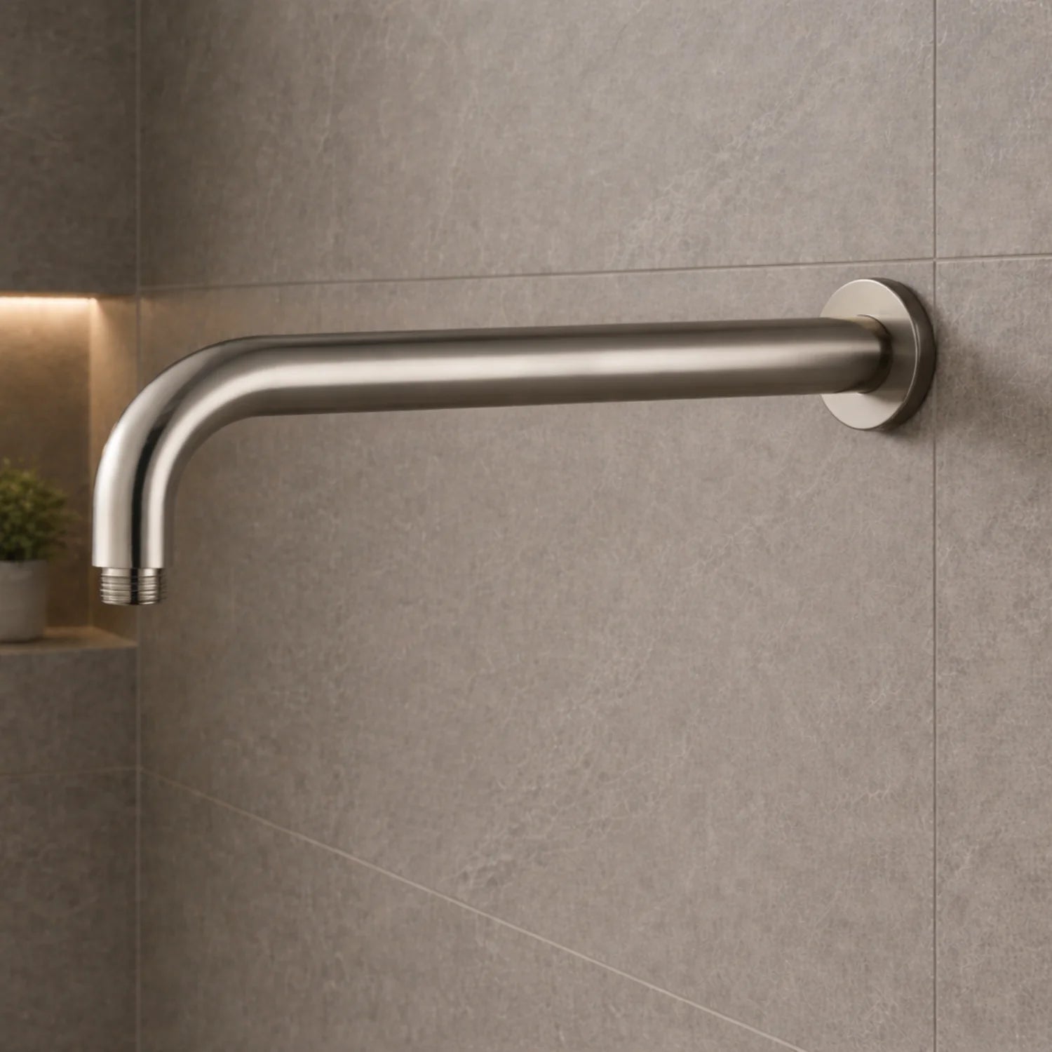 Metallic shower arm mounted on a tiled wall