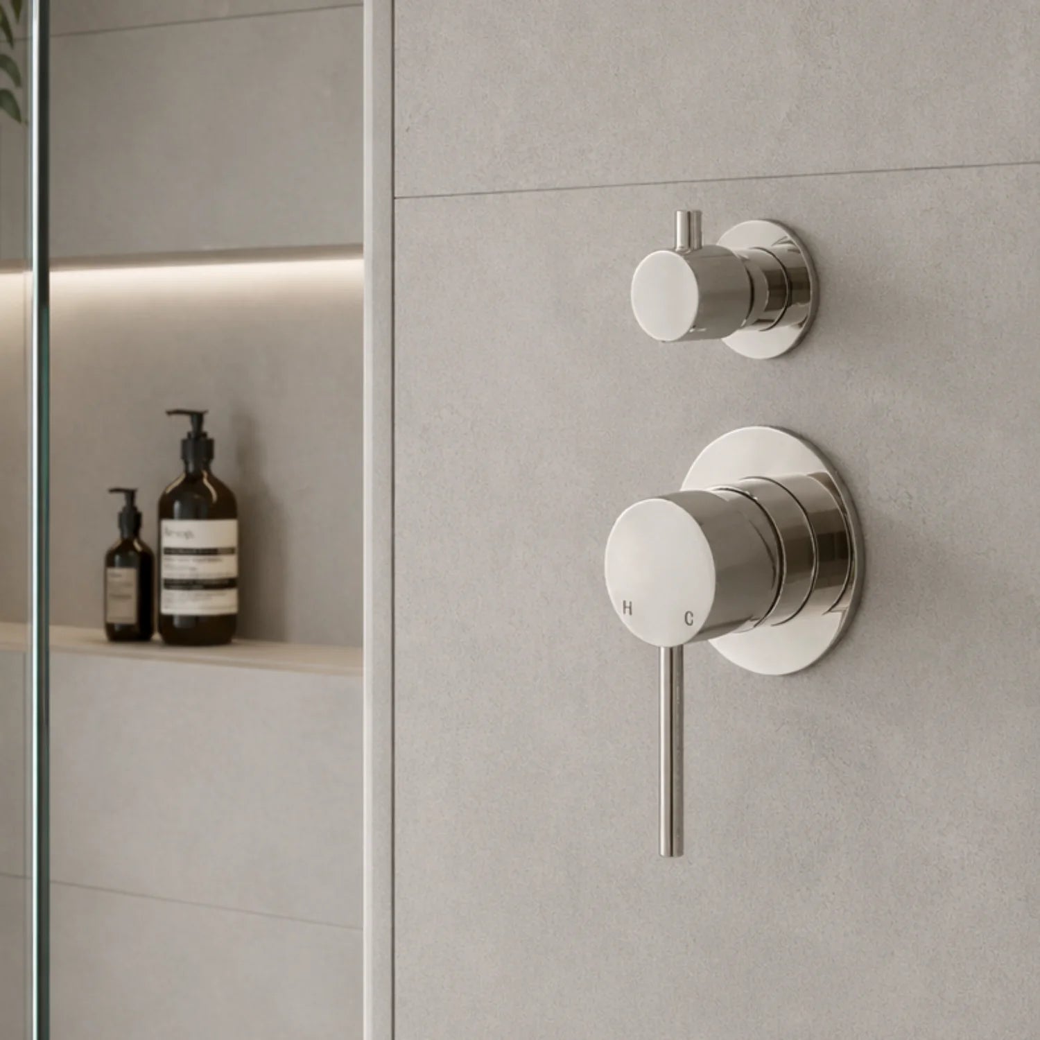 Modern bathroom faucet and shower controls on a tiled wall.